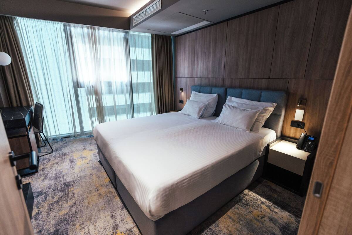 Ein Hotelzimmer mit einem großen Bett, einem Schreibtisch und einem Stuhl.