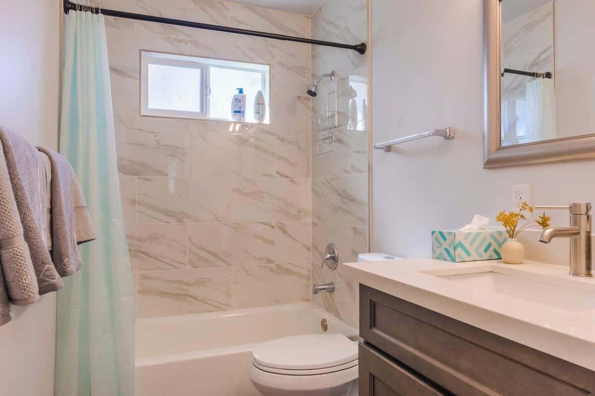 A bathroom with a bathtub, toilet, and a shower area.