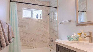Une salle de bain équipée d’une baignoire, de toilettes et d’un espace douche.