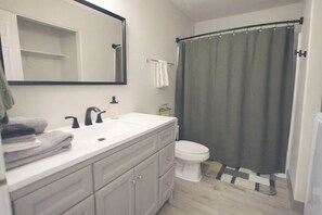 Tina con regadera, secadora de cabello, toallas, jabón 