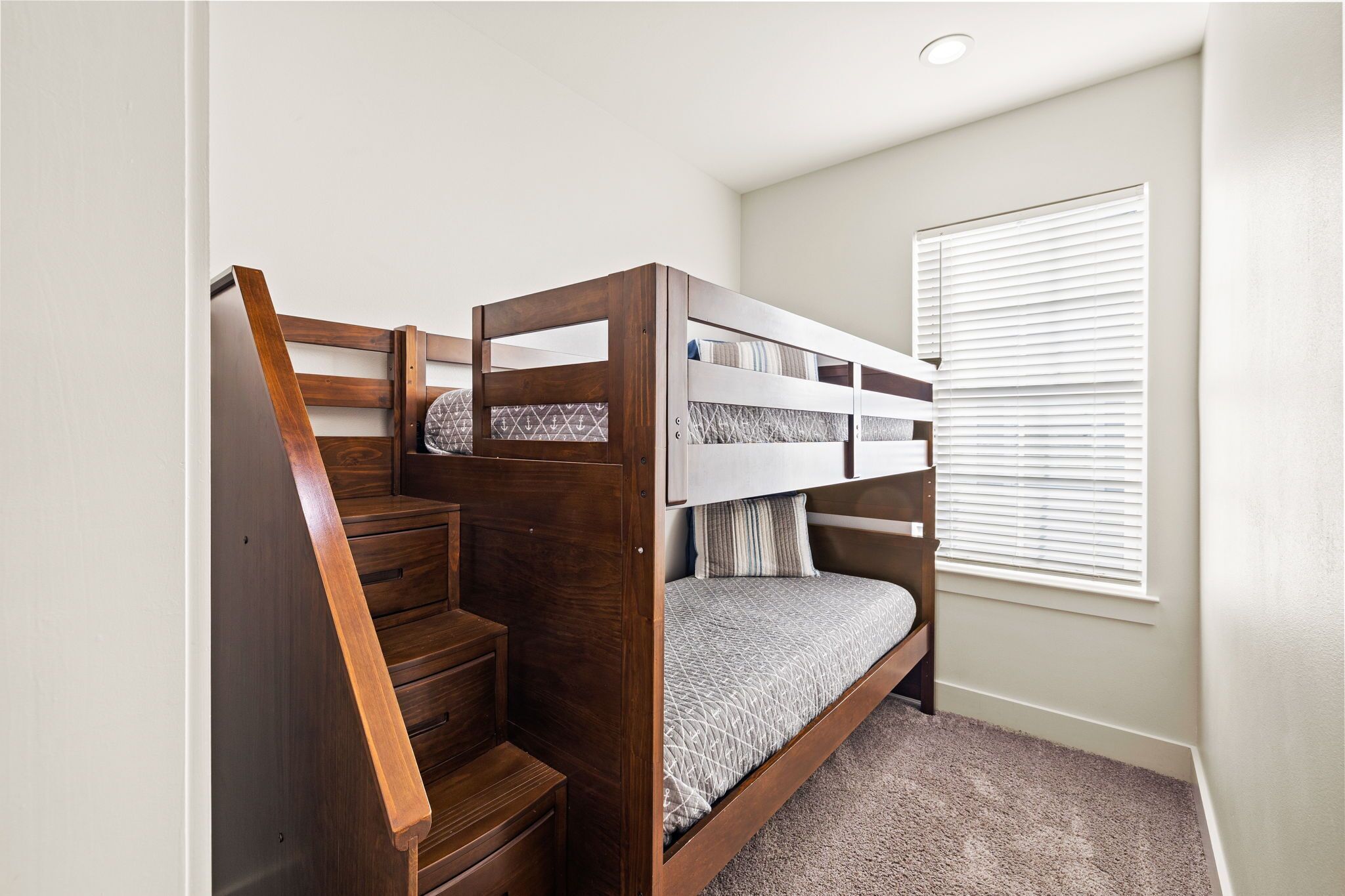 A bunk bed with a wooden frame and a carpeted floor.