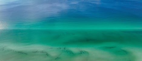 A beach with clear turquoise water and a sandy shore.