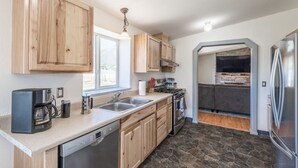 Une cuisine moderne dotée de meubles en bois, d’un lave-vaisselle, d’une cuisinière et d’un réfrigérateur.