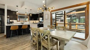 Una cocina moderna con armarios oscuros, una isla central y taburetes de bar.