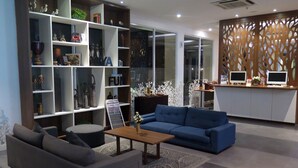 Un saló modern amb un sofà blau, una taula de centre i una prestatgeria plena d'objectes decoratius.