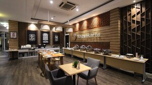 Un restaurant amb una barra llarga, diverses opcions d'asseients i una paret de fusta amb un dibuix de rejola.