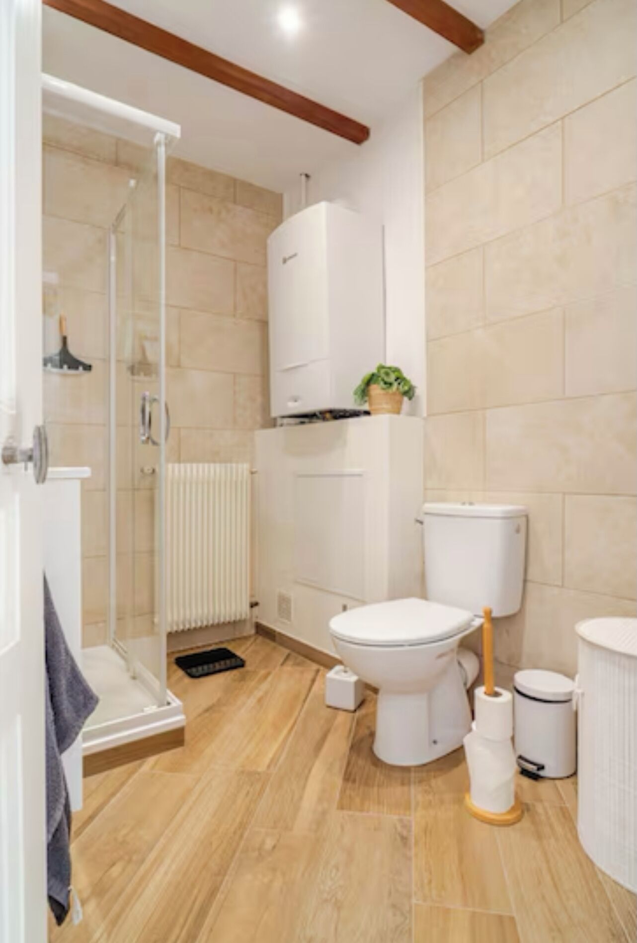 Une salle de bain moderne avec une douche à parois de verre, des toilettes, un bidet et un radiateur.