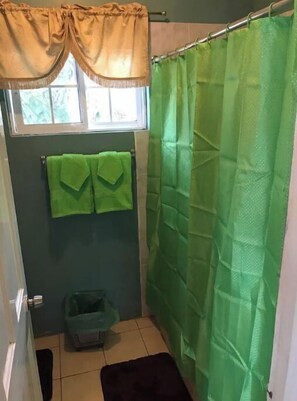 Een douche, handdoeken, zeep, toiletpapier