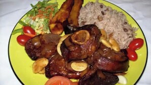 Un piatto con diversi cibi, tra cui riso, carne e verdure.