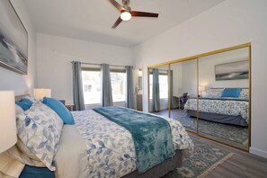 A bedroom with a large bed, a ceiling fan, a mirror, and a view of the outside. - 2Bed 2Bath APT walking distance to BEACH and BAY i (San Diego)