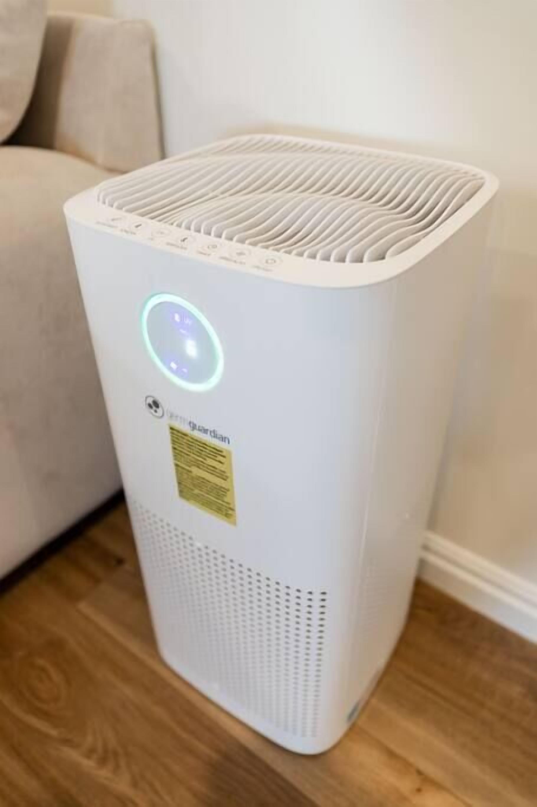 A white portable air purifier with a circular light indicator and a label reading "Guardian."