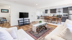 Un salon moderne avec un téléviseur, un canapé et une table basse.