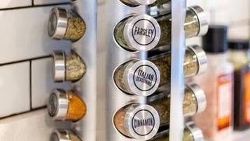 A spice rack with compartments labeled for oregano, parsley, Italian seasoning, cinnamon, and crushed red chili flakes.