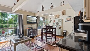 A spacious kitchen with a dining area, large windows, and a view of the outdoors. - 2 bed 2 bath Rustic roost loft condo; deck 2 pools; Lake Taneycomo, & amenities  (Branson)