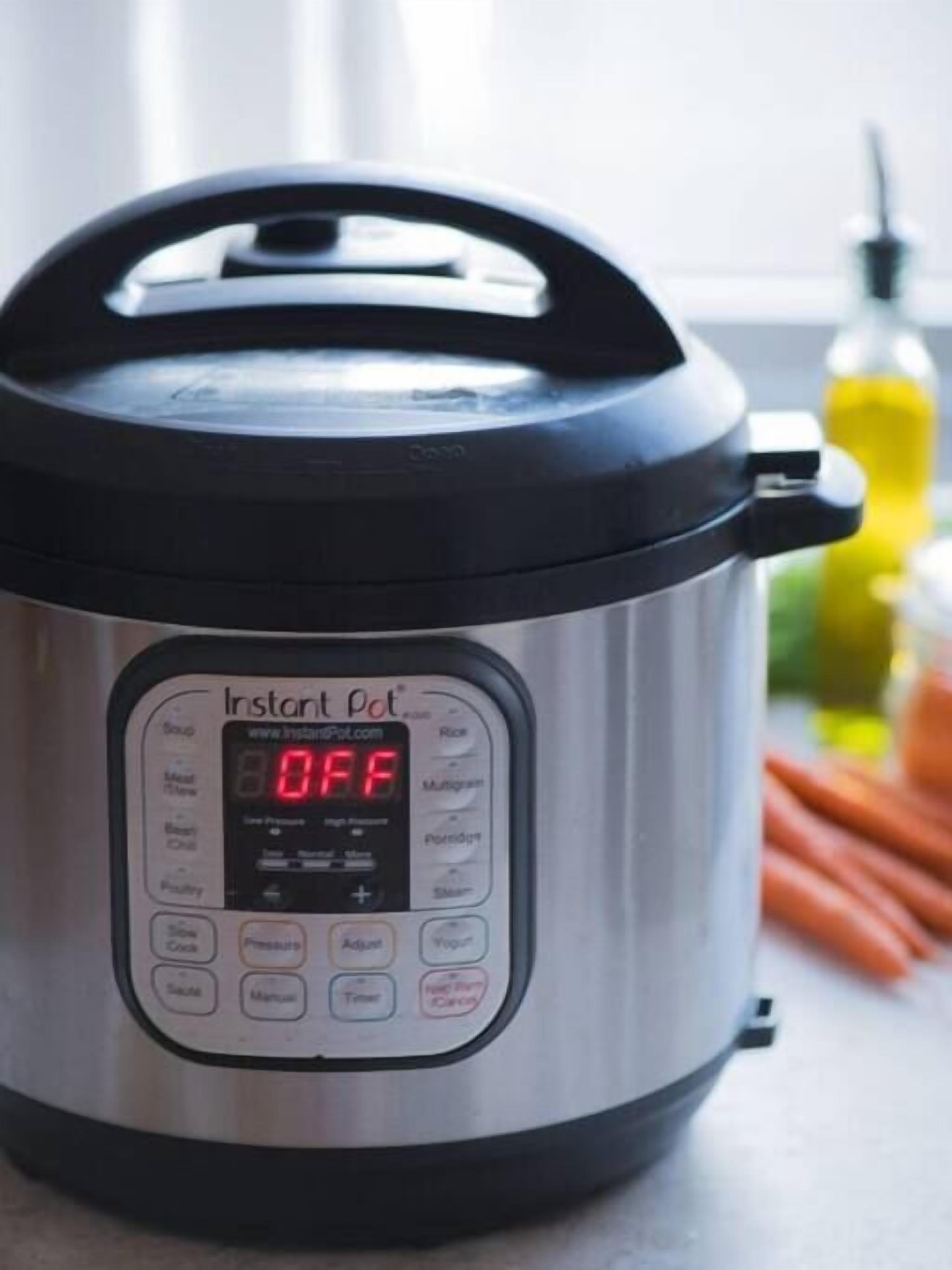 An Instant Pot with a digital display, lid, and handle.