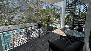 A balcony with a pool, outdoor furniture, and a spiral staircase. - Lido Beach House
 (Sarasota)