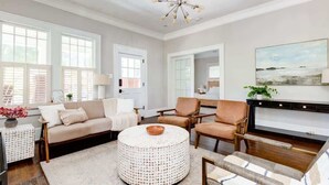 Un salon spacieux avec une table basse ronde, un canapé beige et une cheminée.