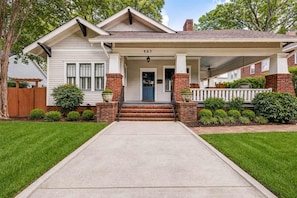 A single-story house with a front porch, a mailbox, and a number '907' on the front.