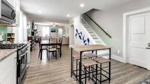 Eine moderne Küche mit Essbereich, Holzboden und einer Treppe.