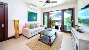 A modern living room with a sofa, coffee table, and artwork on the wall. - 360 Splendor 202-Condo with Breakfast Included (360 Splendor)