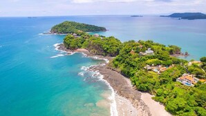 An aerial view of a coastal area with a beach, lush greenery, and several buildings. - 360 Splendor 205-Condo with Breakfast Included (360 Splendor)