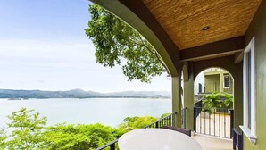 A balcony with a table and chairs overlooking a lake and mountains. - 360 Splendor 206-Condo with Breakfast Included (360 Splendor)
