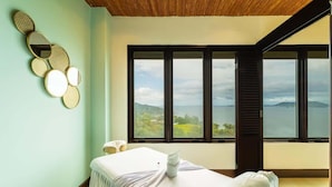 A spa room with a massage table, a wall-mounted mirror, and a large window offering a view of the landscape. - 360 Splendor 207F- 3 BR Condo, Breakfast Included (360 Splendor)