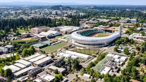 An aerial view of a university campus with a large stadium, multiple buildings, and surrounding greenery. - Remodeled 2 bdrm duplex near the U of O (Eugene)
