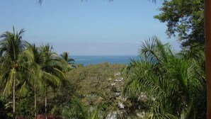 A tropical landscape with palm trees and a view of the ocean. - Casa Coco  Ocean/Jungle view Studio (Sayulita)