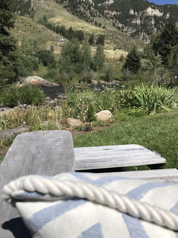 A rustic outdoor seating area with a stone bench and a rope.