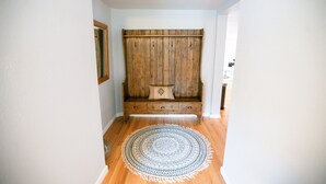 A hallway with a wooden bench, a patterned rug, and a wooden wall. - Cozy Turns- Vail/ Minturn Colorado (Minturn)