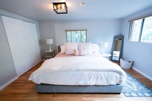 A bedroom with a large bed, a nightstand, a lamp, a window, and a wardrobe. - Cozy Turns- Vail/ Minturn Colorado (Minturn)
