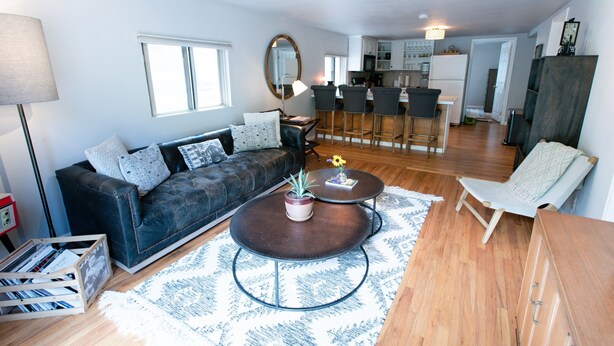 A modern living room with a dark leather sofa, two round coffee tables, and a wooden cabinet. - Cozy Turns- Vail/ Minturn Colorado (Minturn)