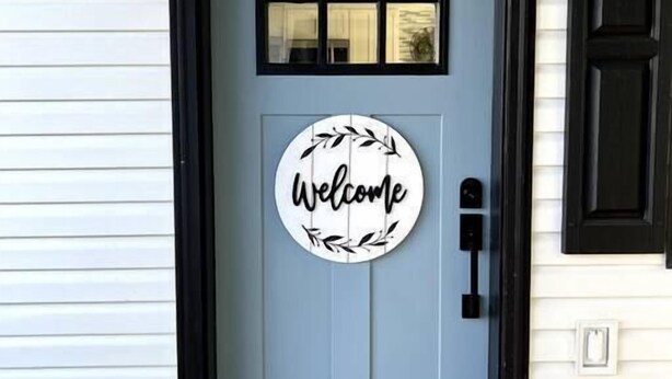 A front door with a 'Welcome' sign, a mailbox, and a number '3' above it.