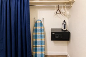 A room with a blue curtain, a plaid ironing board, and a black iron box. - Dreams Negril at Coletta's Restaurant - Studio (Negril)