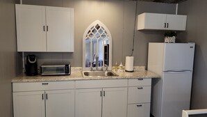 A modern kitchen with white cabinets, a built-in oven, a sink, and a refrigerator. - Safari-ish Cabin Getaway in Jacksboro (Jacksboro)