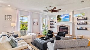 Una sala de estar moderna con chimenea, asientos cómodos y vistas al exterior.