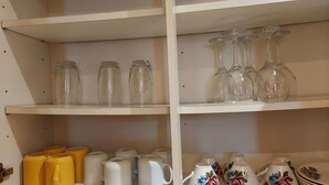 A kitchen shelf with clear glassware and various mugs. - Victoria Heights - Beautiful 3-bed in Gillingham K (Gillingham)