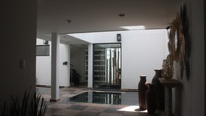 A spacious lobby with a glass partition, a tiled floor, and a few decorative vases. - Kolben Nuoma (Mexico City)