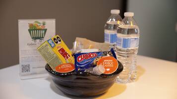 A bowl containing various food items and a water bottle on a table.