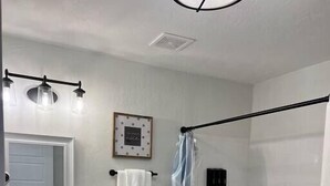 Un baño con inodoro, lavamanos y ducha.