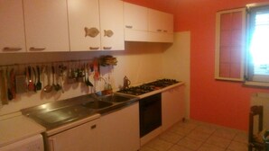 A compact kitchen with white cabinets, a gas stove, and a sink.