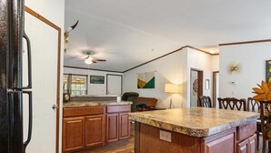 A kitchen with wooden cabinets, a granite countertop, and a ceiling fan. - Hondo Creek Hideaway (Tarpley)