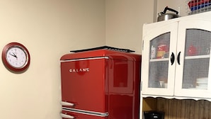 A compact kitchen with a red Galanz refrigerator, a coffee maker, and a white cabinet with a wire basket. - Whitefoot Lodge Studio in Village Centre (Beaverdell)