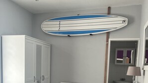 Un dormitorio con cama, armario, radiador, escritorio y espejo.