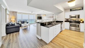 A modern apartment with a kitchen, living area, and balcony.