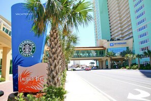 En gatubild med en Starbucks-skylt, ett Wyndham-hotell och en palm.