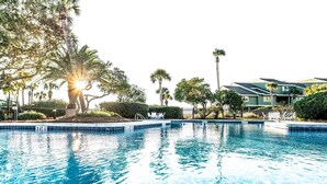 A swimming pool with a 3 FT depth marker, surrounded by palm trees and a fence.