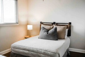 Cozy retreat with a single bed, bedside table, and lamp.