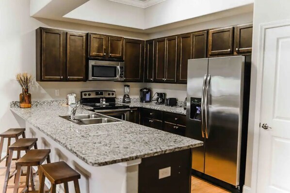 Enjoy cooking in this fully equipped kitchen with a refrigerator, microwave, and sink.